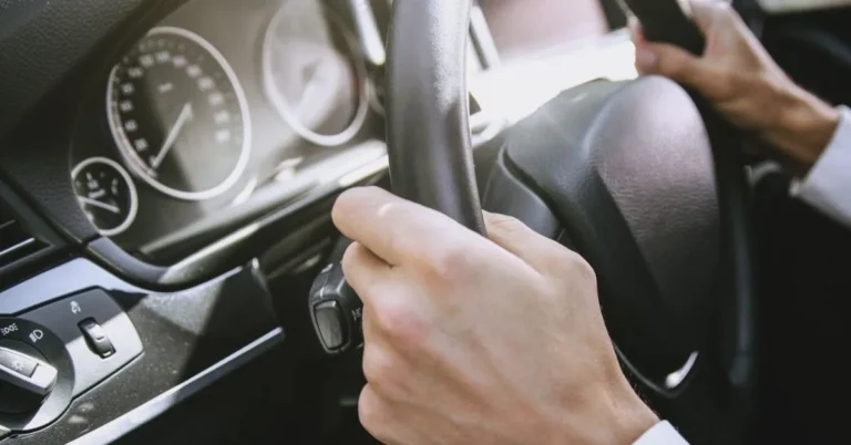primo piano di mani sul volante di un'auto