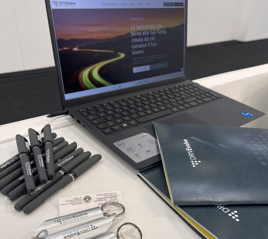 pc aperto sul sito di drivevolve e gadget promozionali in occasione dell'evento fleet manager academy di bologna 2026